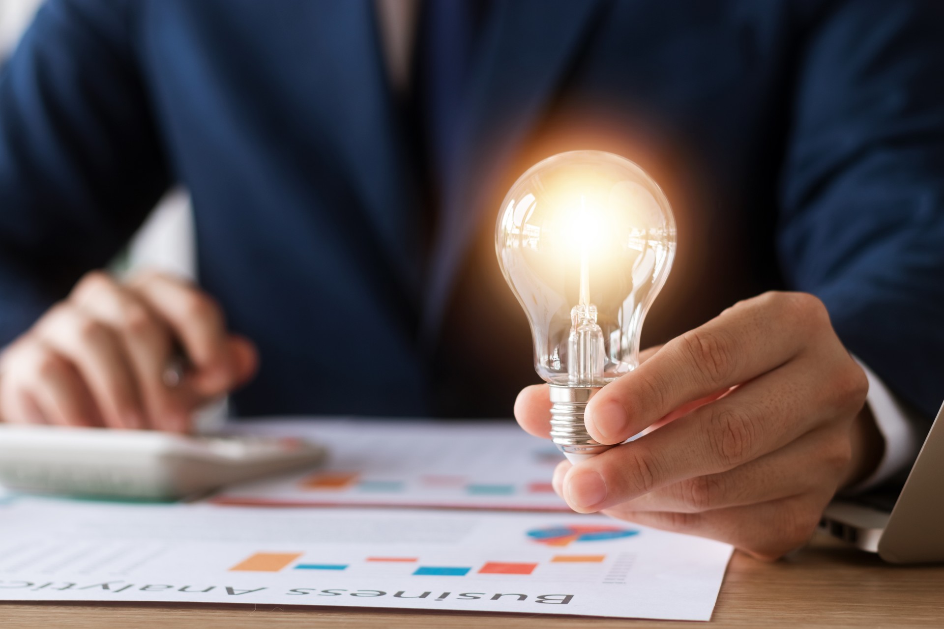 Innovation through ideas and inspiration ideas. Human hand holding light bulb to illuminate, idea of creativity and inspiration concept of sustainable business development.